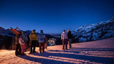 Ausblick auf Berg mit Rodelern bei Nacht