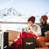 Paar in Apres Ski Bar mit Ausblick